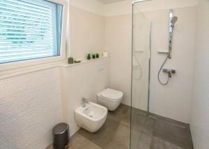 a bathroom with a toilet and a glass shower at House Villa Verdi in Tkon +20 photos