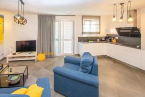 a living room with a blue chair and a kitchen at House Villa Verdi in Tkon