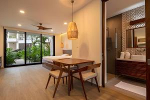 a bedroom with a bed and a table and a bed at Condo Moots 101 with private pool & rooftop yoga in Tulum