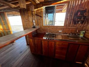 a kitchen with a stove and a sink in a cabin at Casa Coral in Mayapo