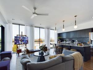 a living room with a couch and a kitchen with windows at Foxtrot Tango - 2 New Homes - 12 South in Nashville