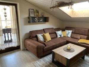 ein Wohnzimmer mit einem braunen Sofa und einem Couchtisch in der Unterkunft Ferienwohnung für 3 Personen ca 46 m in Oberaudorf, Bayern Oberbayern in Oberaudorf
