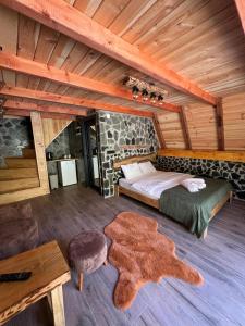 a bedroom in a log cabin with a bed and a rug at Serona Apart & Bungalow in Çamlıhemşin