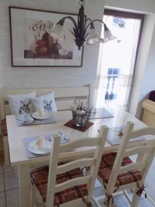 ein weißer Esstisch mit 2 Stühlen, einem Tisch und einem Stuhl in der Unterkunft Ferienwohnung für 3 Personen ca 46 m in Oberaudorf, Bayern Oberbayern in Oberaudorf
