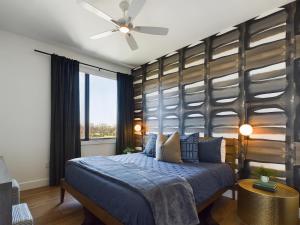 a bedroom with a blue bed and a large window at Foxtrot Tango - 2 New Homes - 12 South in Nashville