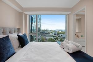 a bedroom with a white bed with a large window at Hobson Apartment with Pool and View in Auckland +25 photos