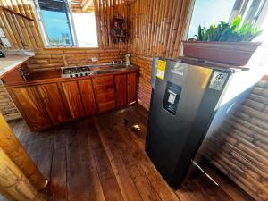 eine Küche mit einem schwarzen Kühlschrank und einer Spüle in der Unterkunft Casa Coral in Mayapo