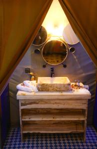 a bathroom with a sink and a mirror at RiadSuerteloca Merzouga in Merzouga