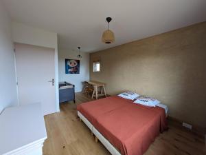 a bedroom with a bed and a desk in it at Terre de Sienne in Saint-Clair