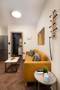 a living room with a yellow couch and two tables at LP Luxury Citycenter Apartment in Serres
