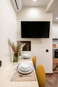 a dining room with a table and a tv on a wall at LP Luxury Citycenter Apartment in Serres