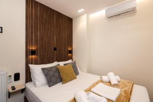 um quarto com uma cama com lençóis brancos e almofadas em LP Luxury Citycenter Apartment em Serres