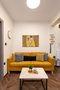 a living room with a yellow couch and a table at LP Luxury Citycenter Apartment in Serres