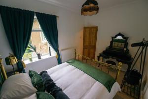 Schlafzimmer mit einem Bett mit grünen Vorhängen und einem Fenster in der Unterkunft Number 2 in Mountain Ash