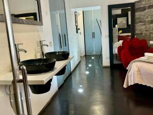 ein Badezimmer mit zwei Waschbecken und einer roten Couch in der Unterkunft Azadi Rome Center in Rom