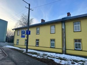 un edificio amarillo con una señal de estacionamiento delante de él en VILMSI 52 APARTMENTS, en Tallin