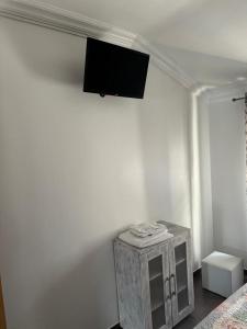 Zimmer mit einem TV an einer weißen Wand in der Unterkunft Biá's House in Nazaré