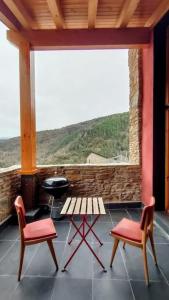 a porch with two chairs and a table and a grill at Cal cavalé in Vall de Castellbò +30 photos