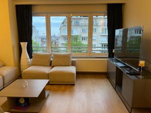een woonkamer met een bank en een groot raam bij Studio Winston Churchill in Brussel