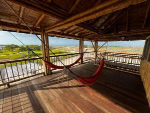 - une terrasse couverte avec 2 hamacs suspendus au toit dans l'établissement Casa Coral, à Mayapo