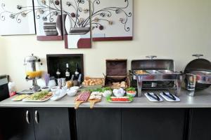 a buffet with food and bottles of wine on a counter at East Gate Boutique Hotel in Tbilisi City