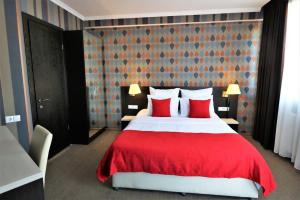 1 dormitorio con 1 cama grande con almohadas rojas en East Gate Boutique Hotel en Tiflis