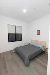 um quarto com uma cama e duas janelas em Chic 2-Bed Getaway Home-mins to NYC em Bayonne