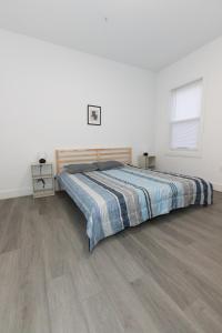 um quarto com uma cama e piso em madeira em Chic 2-Bed Getaway Home-mins to NYC em Bayonne