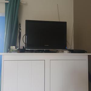 TV de pantalla plana en la parte superior de un armario blanco en Appartement 2p Le Havre en Le Havre