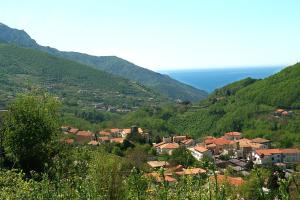 a small town in a valley with mountains and the ocean at Farfalle e Gabbiani in Tramonti