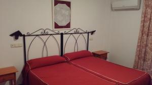 a bedroom with a red bed with a red blanket at Hotel Restaurante Segobriga in Villas Viejas