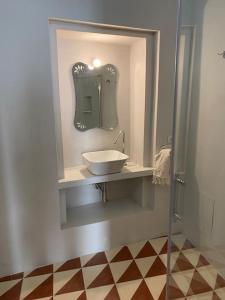 un baño con lavabo y espejo en Appartamento in antica casa, en Vernole
