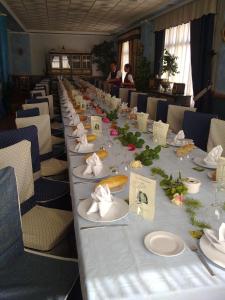 una mesa larga con platos blancos y servilletas. en Hotel Restaurante Segobriga, en Villas Viejas