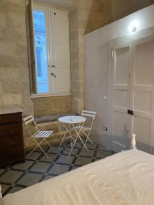 Un dormitorio con dos sillas y una mesa y una cama. en Appartamento in antica casa, en Vernole
