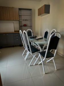 ein Esszimmer mit einem Glastisch und 4 Stühlen in der Unterkunft Residencial Mirandinha. in Boa Vista
