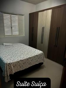 a bedroom with a bed and wooden cabinets at Residencial Mirandinha. in Boa Vista