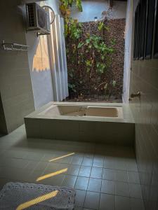 a bath tub in a bathroom with a plant at Residencial Mirandinha. in Boa Vista
