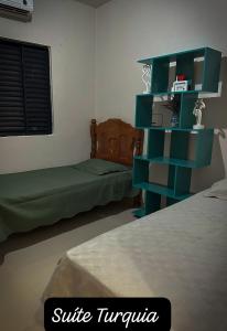 a bedroom with two beds and a blue shelf at Residencial Mirandinha. in Boa Vista