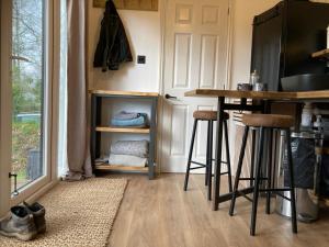 a kitchen with a counter and stools in a room at The Cabin in the Woods in Romsey