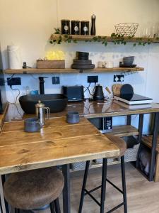 a kitchen with a wooden table and two stools at The Cabin in the Woods in Romsey