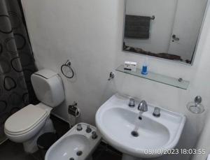 a white bathroom with a toilet and a sink at Departamento “Edificio Manuelita” in Resistencia