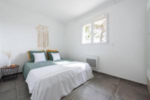 Villa spacieuse au calme في Sainte-Anastasie-sur-Issole: غرفة نوم بيضاء بها سرير ونافذة