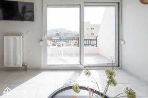 een witte kamer met uitzicht op een balkon bij Agora Central Home in Chalkida