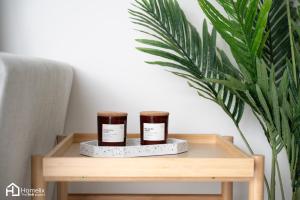 two jars on a wooden table next to a plant at Agora Central Home in Chalkida