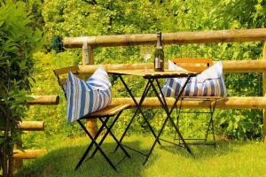 een picknicktafel met 2 stoelen en een fles wijn bij Helle Ferienwohnung in Santo mit Garten, gemeinsamem Pool und Terrasse in Castion Veronese