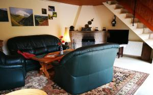 ein Wohnzimmer mit einem Ledersofa und einem Tisch in der Unterkunft Studio für 4 Personen ca 85 qm in Waldbreitbach, Rheinland-Pfalz Westerwald in Waldbreitbach