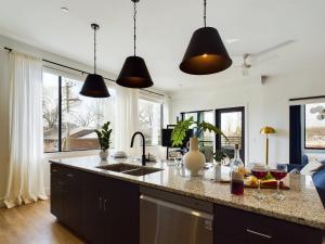 a kitchen with two pendant lights above a kitchen counter at Fox Hollow - 2 New Homes - Downtown Views in Nashville