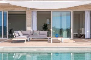 eine Couch auf einer Terrasse neben einem Pool in der Unterkunft Nettes Ferienhaus in Acqualagna mit Großem Garten in Acqualagna
