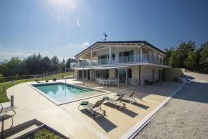 uma casa grande com uma piscina em frente em Nettes Ferienhaus in Acqualagna mit Großem Garten em Acqualagna