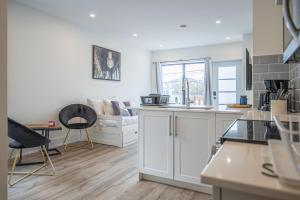 a kitchen with white cabinets and a living room at Private Unit in the heart of Ottawa, 3 minutes to downtown Ottawa in Ottawa